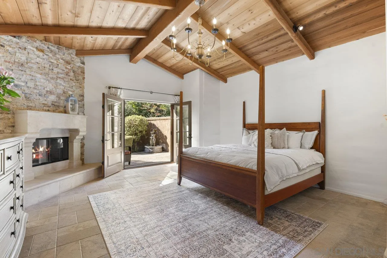 6101 Camino Selva Rancho Santa Fe, CA 92067 - Photo 17 of 35 a white bed sitting in a room next to a fireplace
