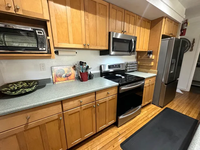 a kitchen with stainless steel appliances a stove a sink a microwave and refrigerator