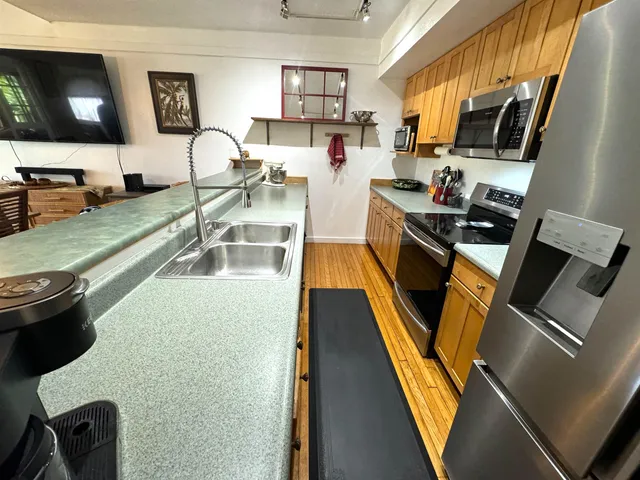 a view of a kitchen with kitchen island and stainless steel appliances