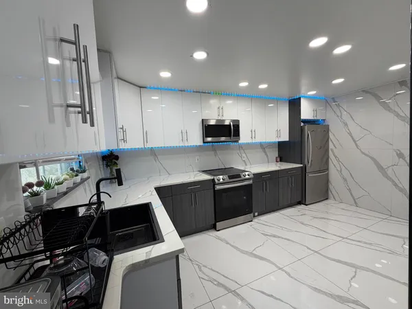 a kitchen with granite countertop a sink cabinets and stainless steel appliances