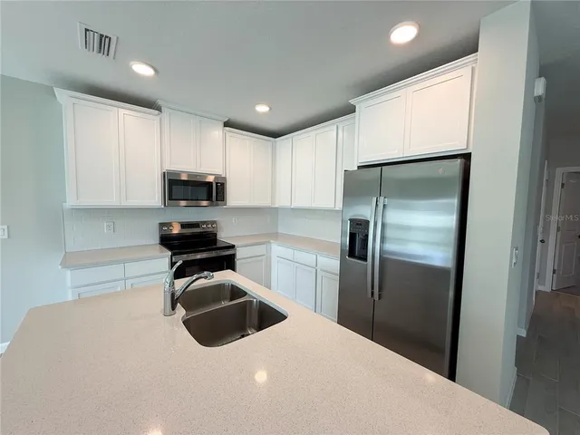 a kitchen with granite countertop a refrigerator and a sink