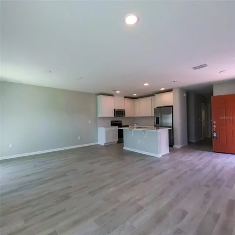 a kitchen with kitchen island a refrigerator a sink a stove a microwave and cabinets