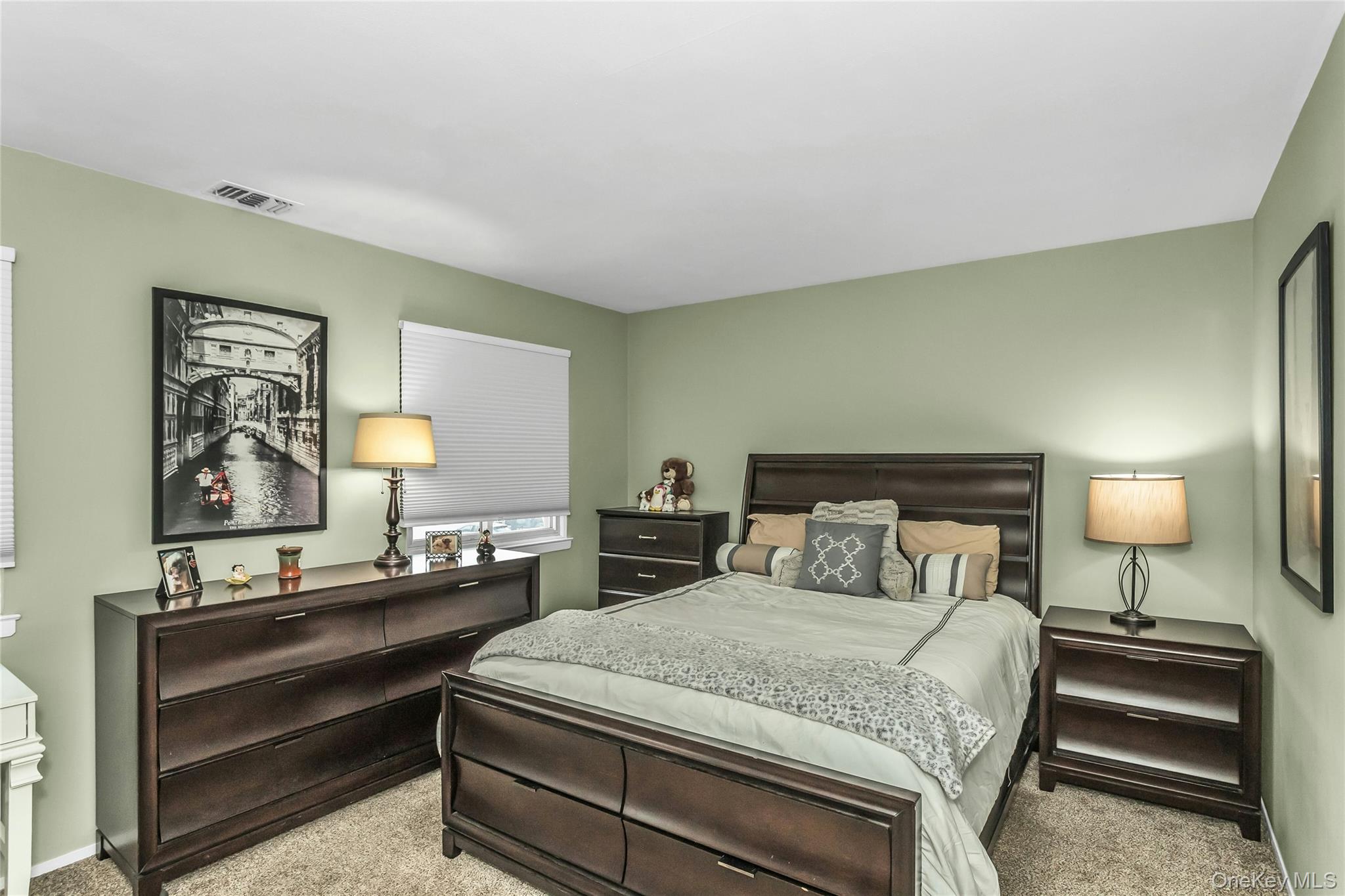 650 Newbridge Road, Unit 9 East Meadow, NY 11554 - Photo 6 of 9 a bedroom with a bed and a lamp on table