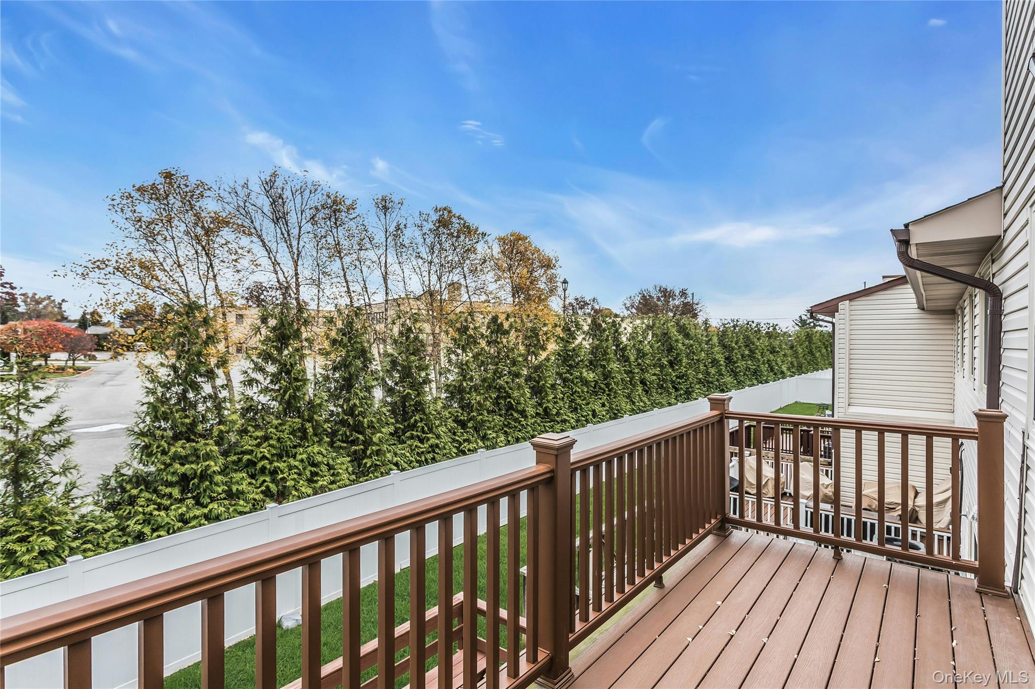 650 Newbridge Road, Unit 9 East Meadow, NY 11554 - Photo 8 of 9 a balcony with wooden floor and fence