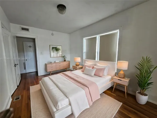 a bedroom with a bed and a potted plant