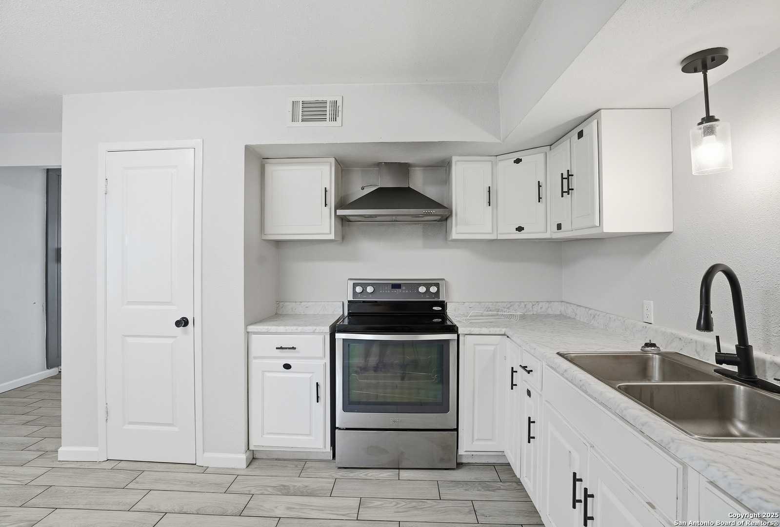 807 Northeast Frontage Road Beeville, TX 78102 - Photo 13 of 49 a kitchen with white cabinets and appliances