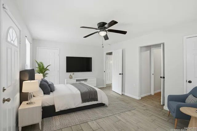 a bedroom with a bed a couch and a flat screen tv