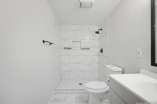 a white toilet sitting next to a bathroom sink