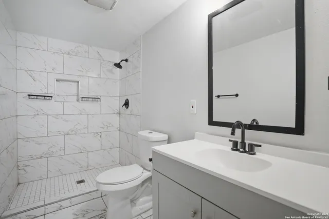 a bathroom with a sink toilet and shower