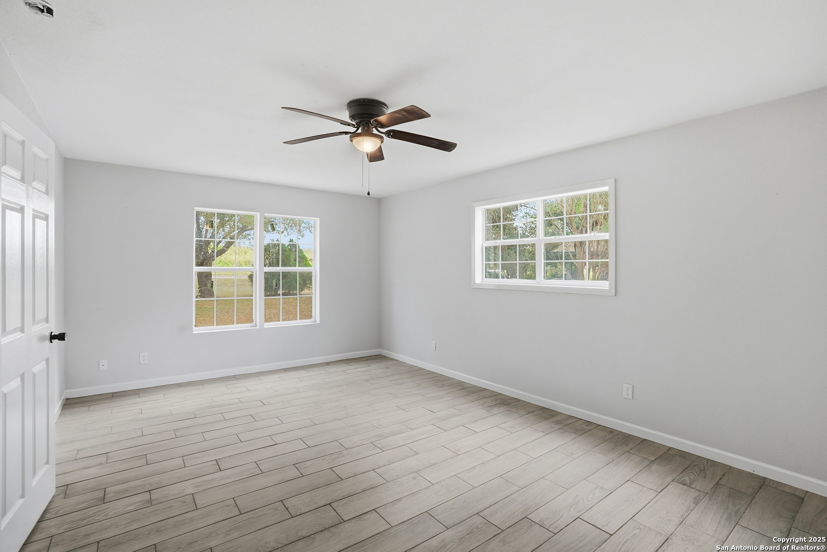 807 Northeast Frontage Road Beeville, TX 78102 - Photo 22 of 49 a view of empty room with wooden floor and fan