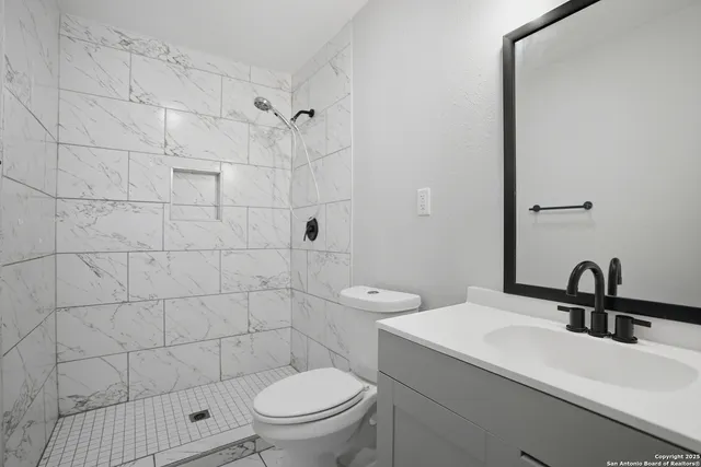a bathroom with a sink toilet and shower