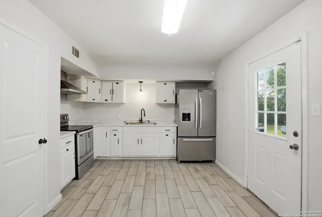 a kitchen with cabinets oven and a sink