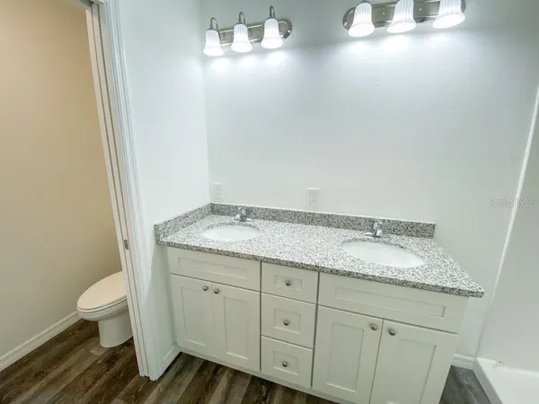 a bathroom with a granite countertop sink and a mirror