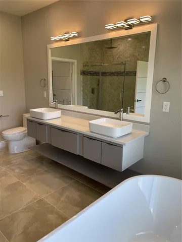 a bathroom with a sink a toilet and mirror