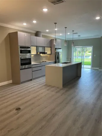 a large kitchen with kitchen island a sink stainless steel appliances and cabinets
