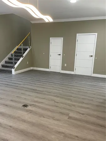 a view of an empty room with wooden floor