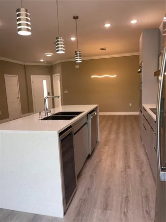 a kitchen with stainless steel appliances granite countertop a sink a stove and a wooden floors