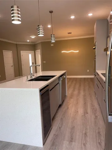 a kitchen with stainless steel appliances granite countertop a sink a stove and a wooden floors