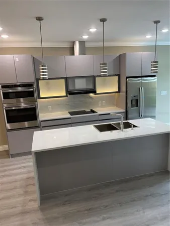 a kitchen with kitchen island a counter space a sink appliances and cabinets