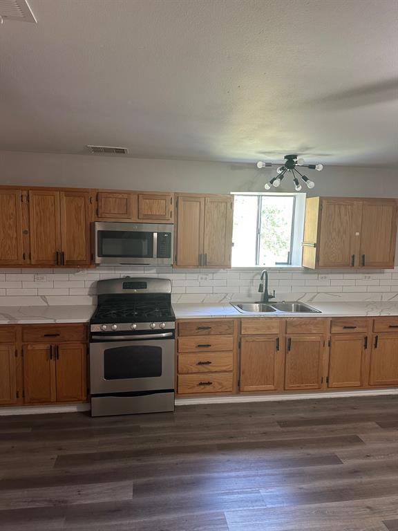 8280 Highway 78 Blue Ridge, TX 75424 - Photo 5 of 21 Kitchen with stainless steel range, light countertops, backsplash, dark wood-style flooring, and a textured ceiling