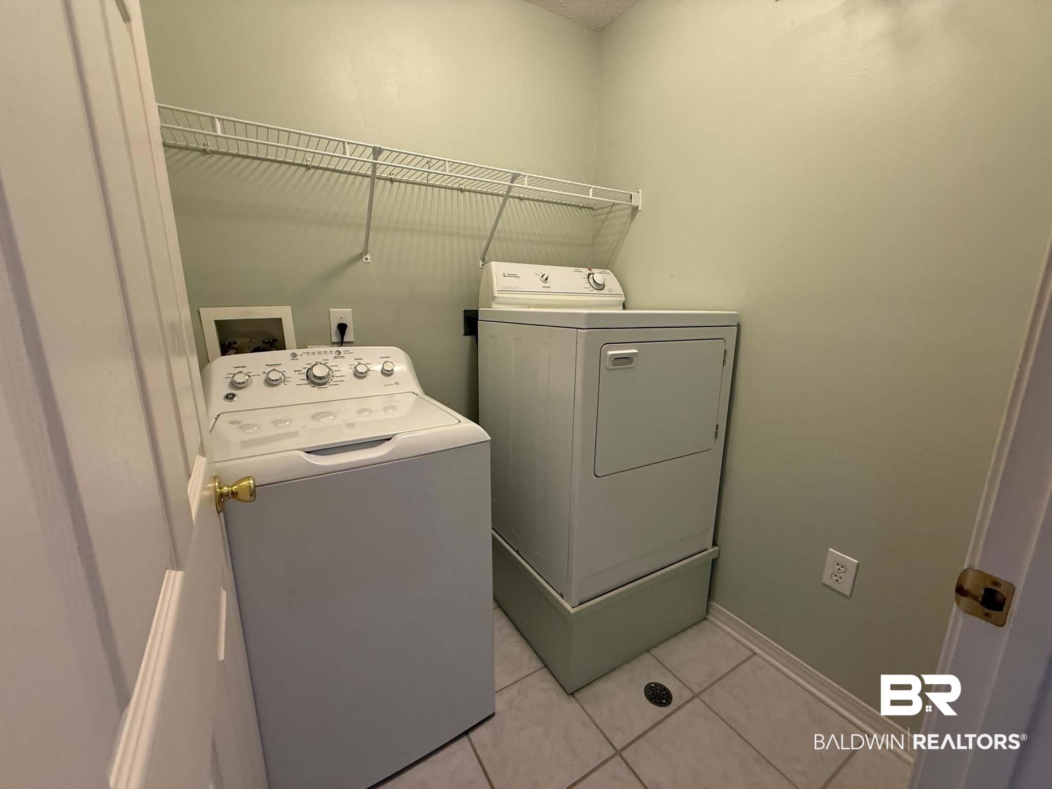 123 Pennbrooke Loop Foley, AL 36535 - Photo 39 of 49 Dedicated laundry area featuring tile flooring, light-toned wall paint, and a built-in wire shelf