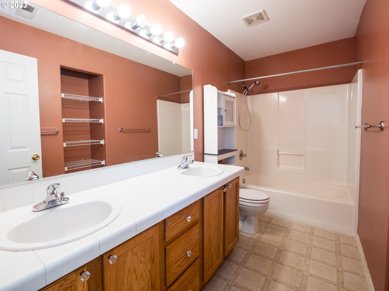 12226 Southeast Long Street Portland, OR 97236 - Photo 22 of 29 a bathroom with a double vanity sink toilet mirror and shower