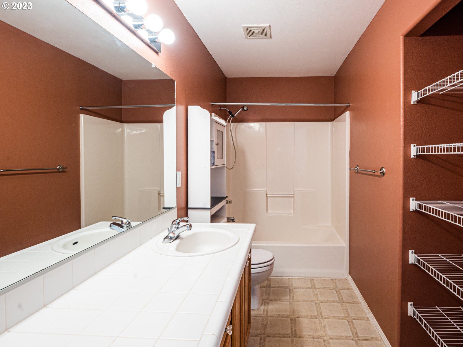12226 Southeast Long Street Portland, OR 97236 - Photo 23 of 29 a bathroom with a double vanity sink a mirror and a bathtub