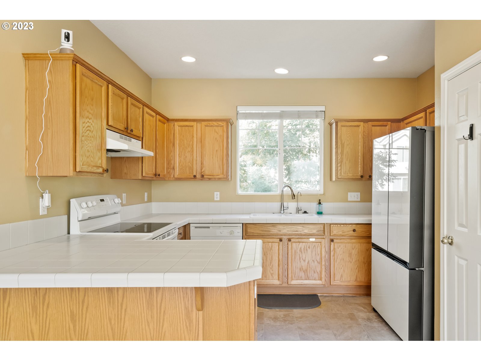 12226 Southeast Long Street Portland, OR 97236 - Photo 9 of 29 a kitchen with stainless steel appliances granite countertop a sink a refrigerator and cabinets