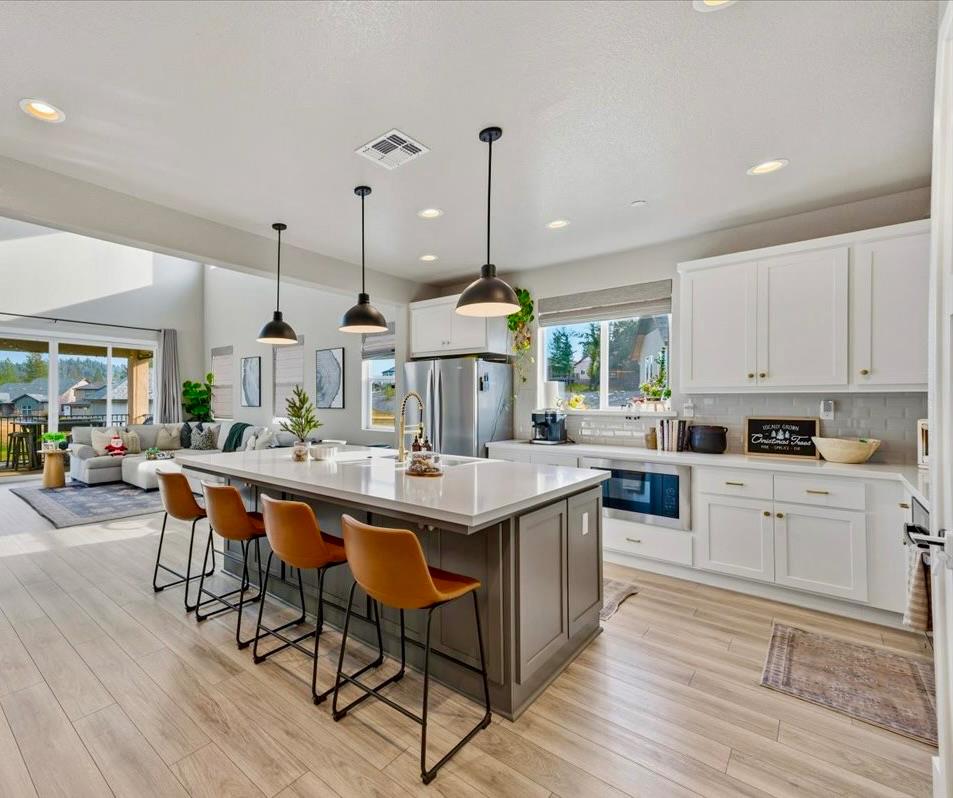 508 Chase Court Colfax, CA 95713 - Photo 2 of 34 a kitchen with stainless steel appliances a dining table chairs stove and white cabinets