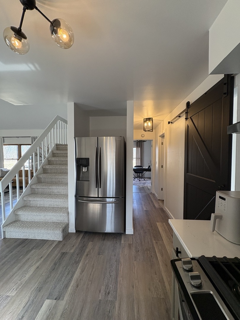 1124 North Clark Lane Elizabeth, IL 61028 - Photo 7 of 50 a kitchen with stainless steel appliances wooden floor and chairs