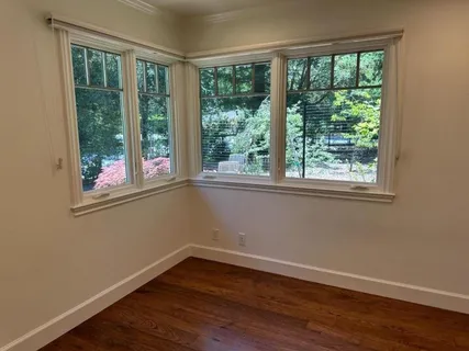 a view of a room with wooden floor and windows
