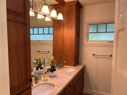 a bathroom with a granite countertop sink and a mirror