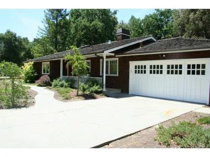 a view of house with yard and trees in the background