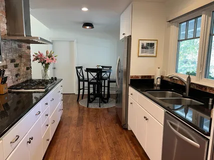 a kitchen with granite countertop a sink stove and cabinets