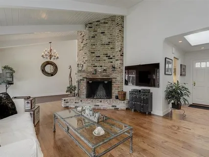 a living room with furniture a flat screen tv and a fireplace