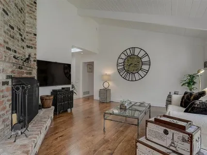 a living room with furniture a flat screen tv and a wall clock