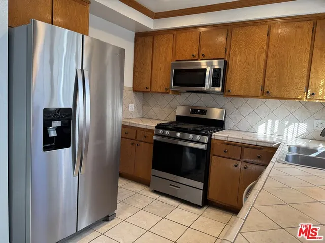 a kitchen with stainless steel appliances granite countertop a refrigerator stove and microwave