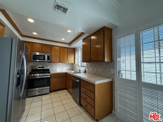 a kitchen with stainless steel appliances granite countertop a stove a sink and a refrigerator