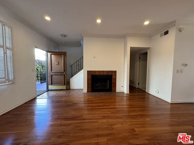 an empty room with wooden floor and fireplace