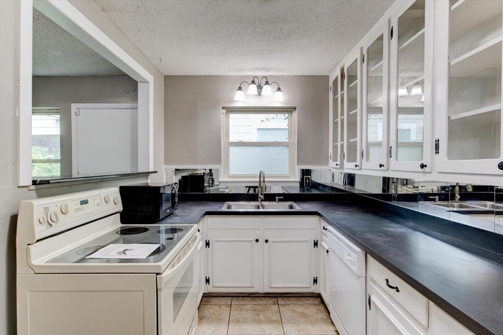 3558 Winston Road Fort Worth, TX 76109 - Photo 7 of 24 a kitchen with granite countertop a sink a stove and cabinets