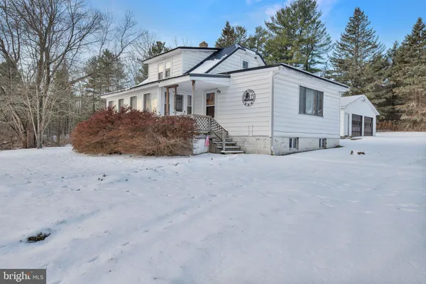 a view of a white house with a yard covered in snow