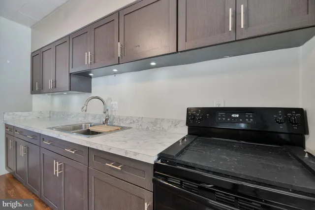 a kitchen with a sink a refrigerator and cabinets