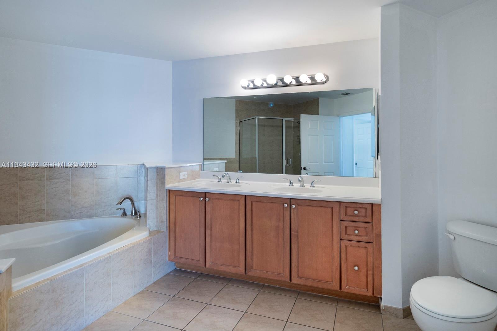 8395 Southwest 73rd Avenue, Unit 528 Miami, FL 33143 - Photo 12 of 27 a bathroom with a sink a large mirror and a bathtub