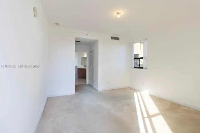 an empty room with windows and closet