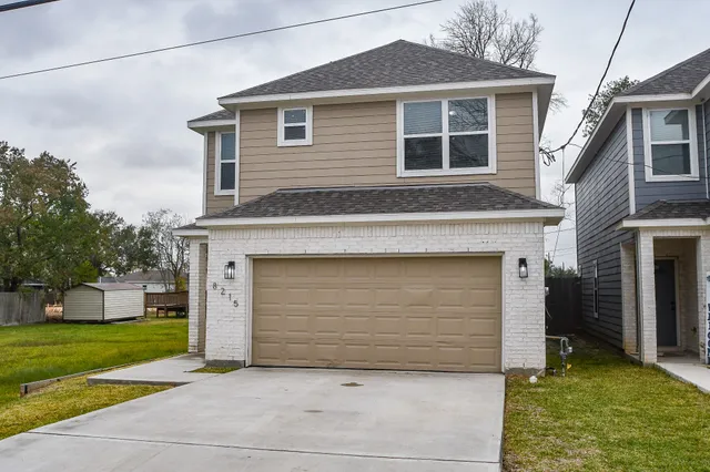 a front view of a house with a garden and garage