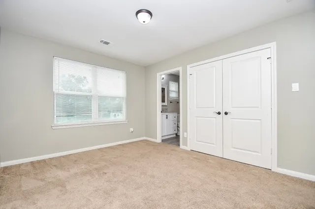 an empty room with windows and closet