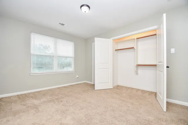 an empty room with windows and closet