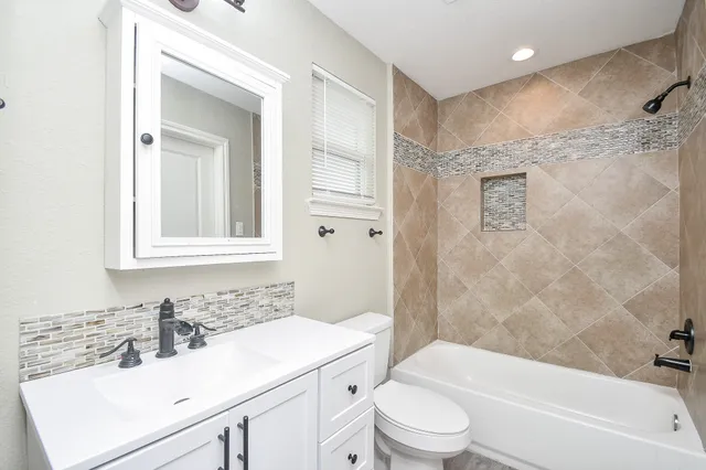 a bathroom with a sink toilet vanity and shower