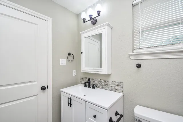 a bathroom with a sink toilet and mirror