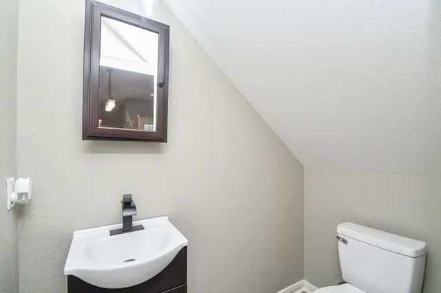 a bathroom with a toilet a sink and mirror